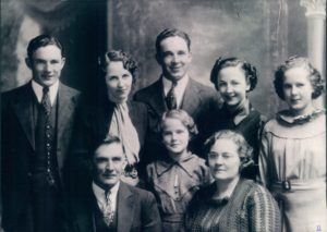 A group of people standing in front of a wall.